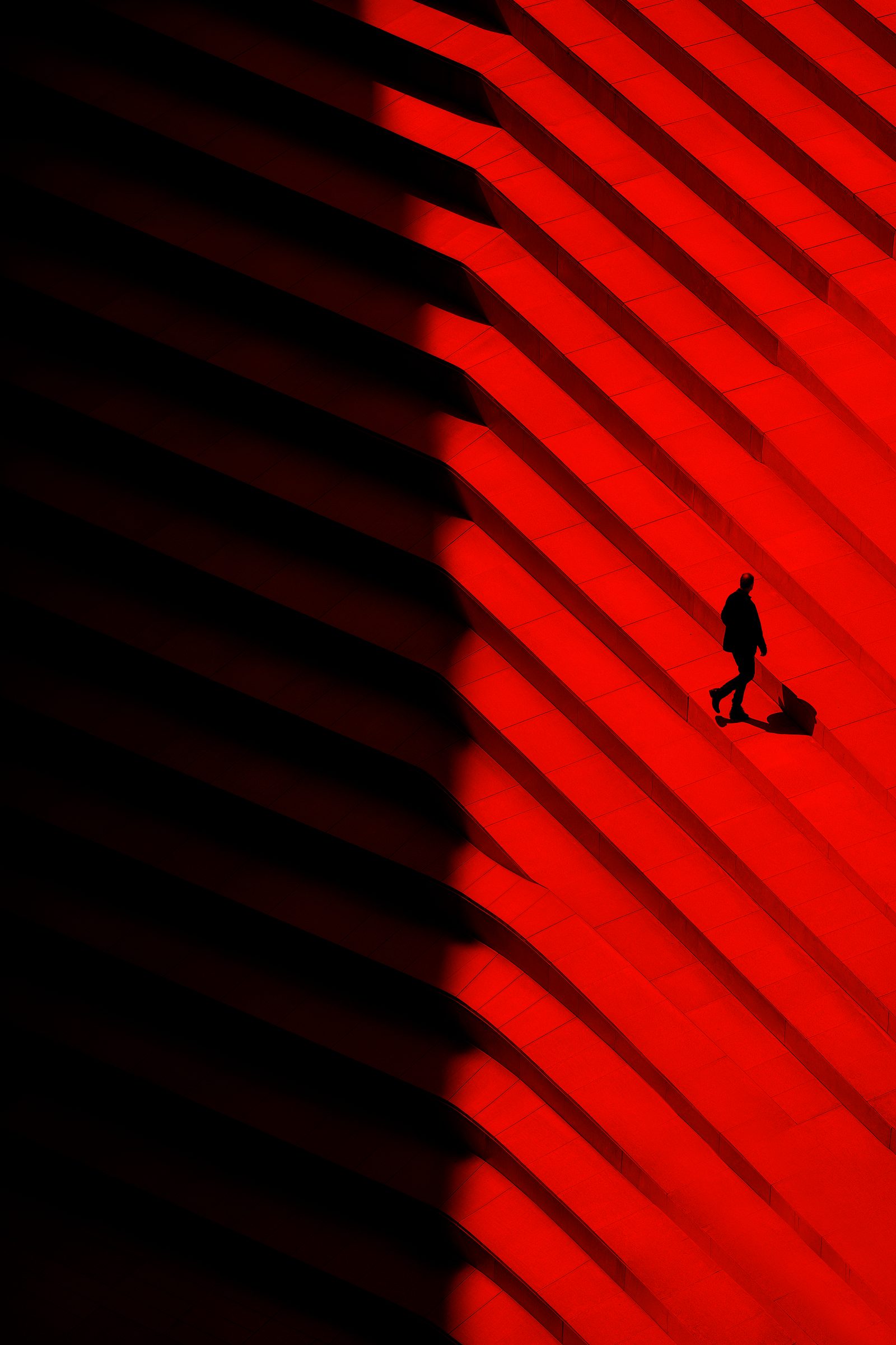 Person walking across a red stair facade